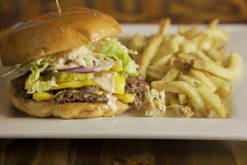 Double cheeseburger with lettuce, onion, pickles, and special sauce, served with french fries.